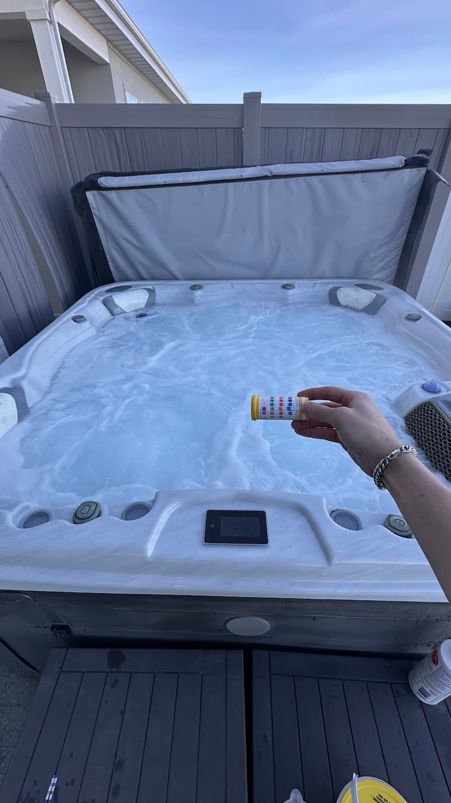 Testing hot tub chemicals with test strip bottle